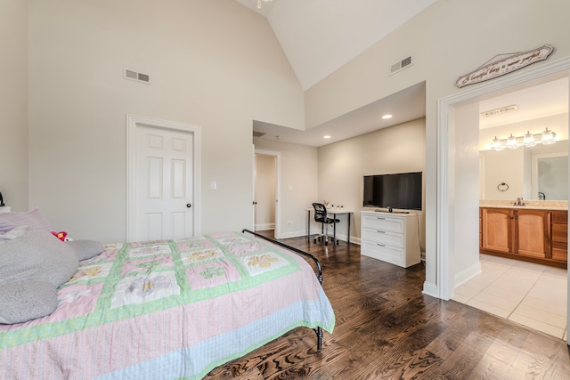 bedroom with hardwood / wood-style flooring, ensuite bathroom, sink, and high vaulted ceiling