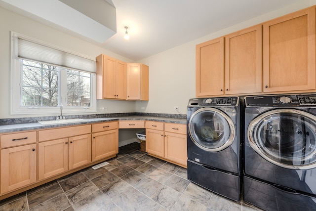 laundry area with washing machine and clothes dryer, sink, and cabinets