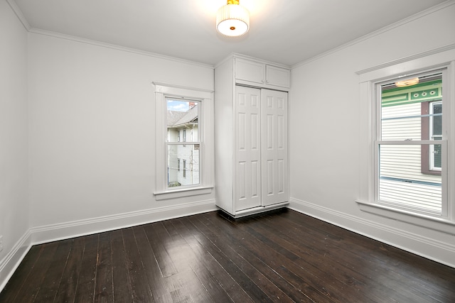 unfurnished bedroom featuring crown molding, dark wood-type flooring, and a closet