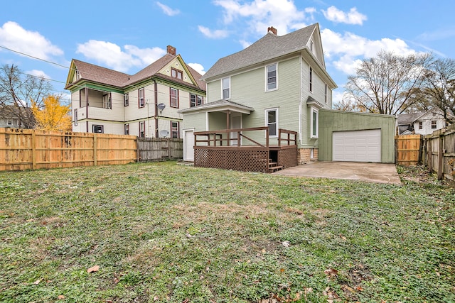 back of property with a garage, a deck, a yard, and a patio