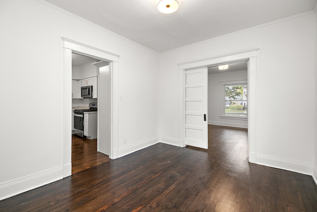 empty room with dark hardwood / wood-style flooring and crown molding