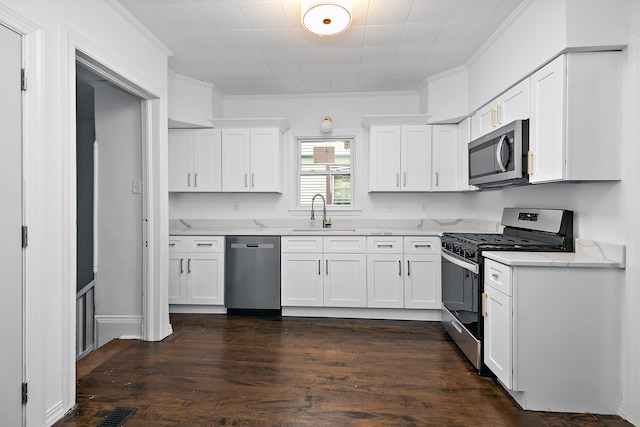 kitchen featuring white cabinets, crown molding, sink, and appliances with stainless steel finishes