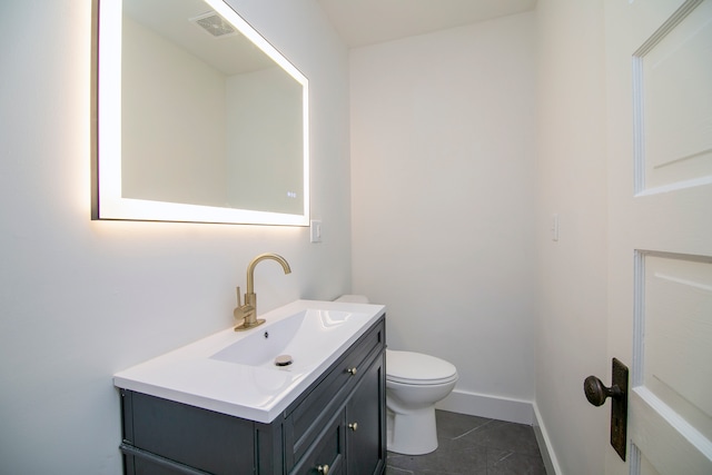 bathroom with tile patterned flooring, vanity, and toilet