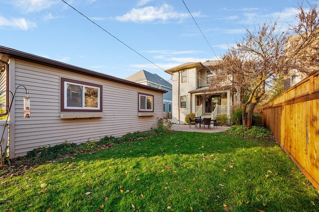 back of house featuring a lawn and a patio