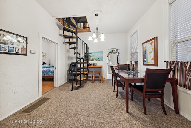 dining space featuring a chandelier and carpet floors