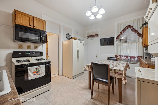 kitchen featuring pendant lighting, white appliances, an inviting chandelier, and light tile patterned floors