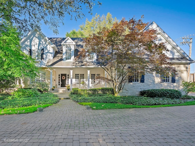 cape cod-style house featuring a porch