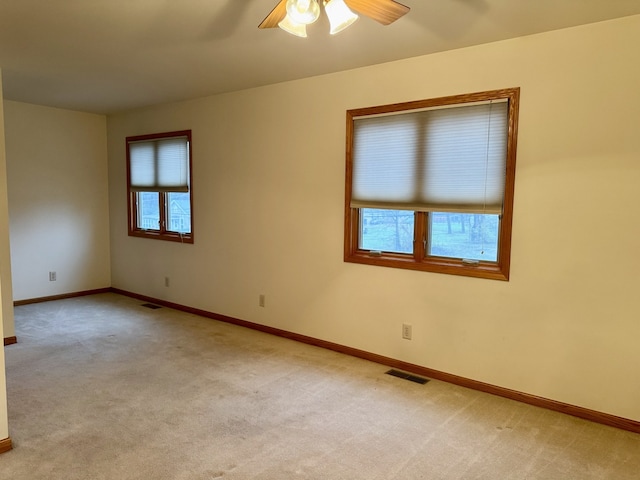 spare room featuring light carpet and ceiling fan