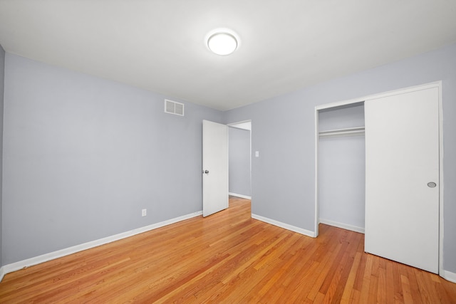 unfurnished bedroom with light hardwood / wood-style floors and a closet