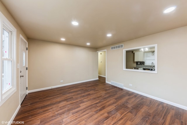 empty room with dark hardwood / wood-style flooring and sink