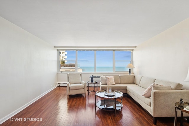 living room with dark wood-style floors, a water view, and baseboards