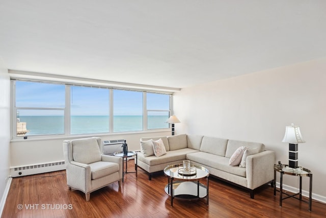 living area with a baseboard heating unit, wood finished floors, a water view, and a wall mounted AC