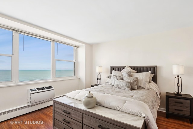 bedroom with a wall unit AC, dark wood-type flooring, a water view, and a baseboard radiator