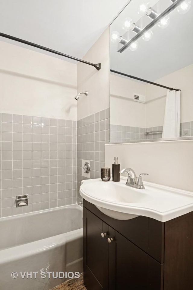 bathroom with shower / bath combo with shower curtain and vanity