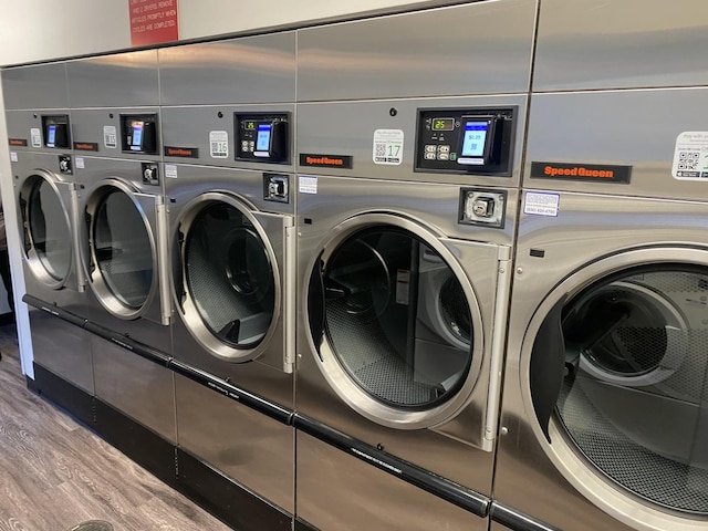 community laundry room featuring washer and dryer and wood finished floors