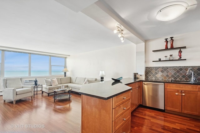 kitchen with a sink, a peninsula, decorative backsplash, dishwasher, and dark wood-style flooring