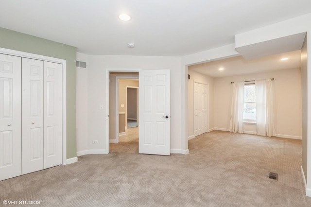 unfurnished bedroom featuring light carpet