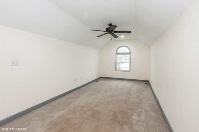 carpeted spare room with ceiling fan and lofted ceiling