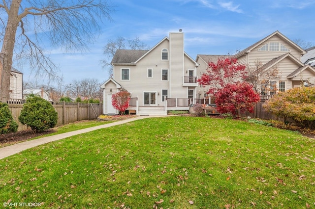 back of house with a lawn and a wooden deck