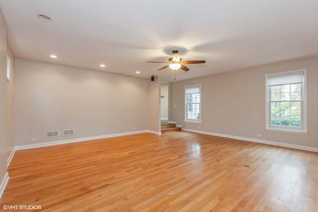 empty room featuring ceiling fan, a wealth of natural light, and light hardwood / wood-style flooring