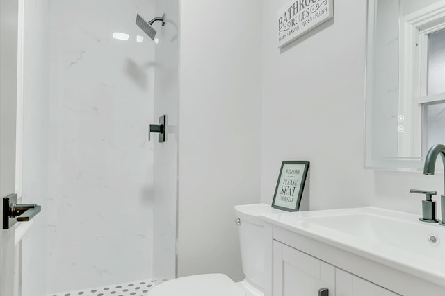 bathroom featuring a shower, vanity, and toilet