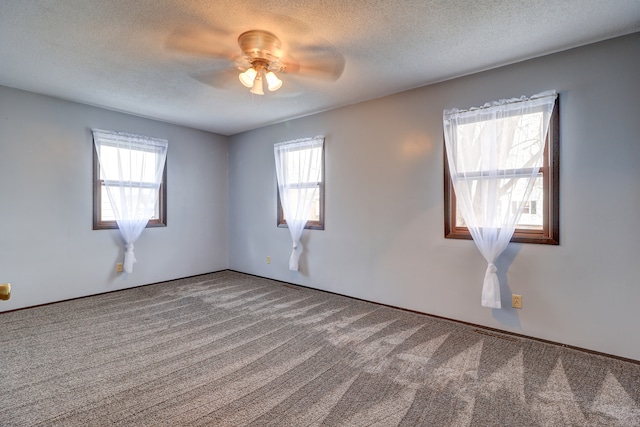 spare room with carpet, ceiling fan, a healthy amount of sunlight, and a textured ceiling