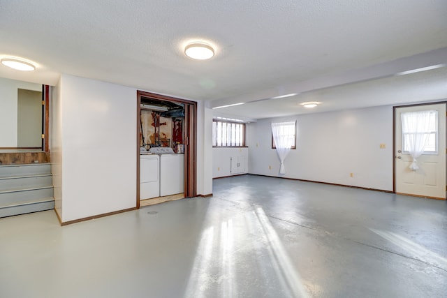 basement featuring a textured ceiling and washing machine and clothes dryer