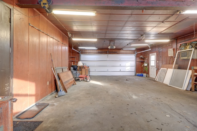 garage featuring a garage door opener and wood walls