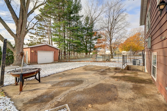 view of patio / terrace featuring an outdoor fire pit, an outbuilding, and a garage