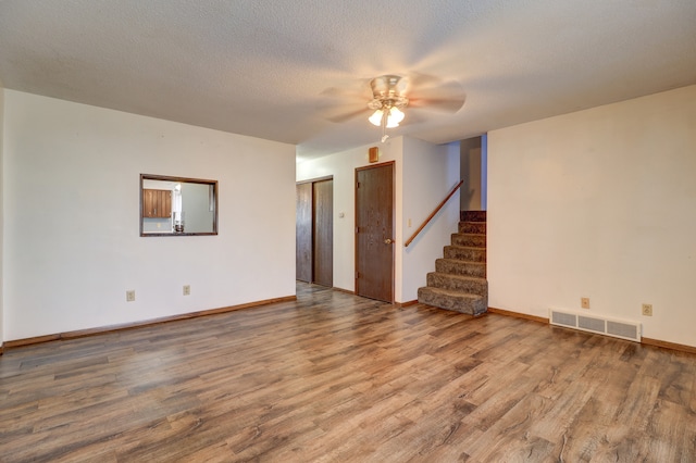 spare room featuring ceiling fan, hardwood / wood-style floors, and a textured ceiling