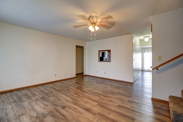 spare room with ceiling fan, wood-type flooring, and a textured ceiling