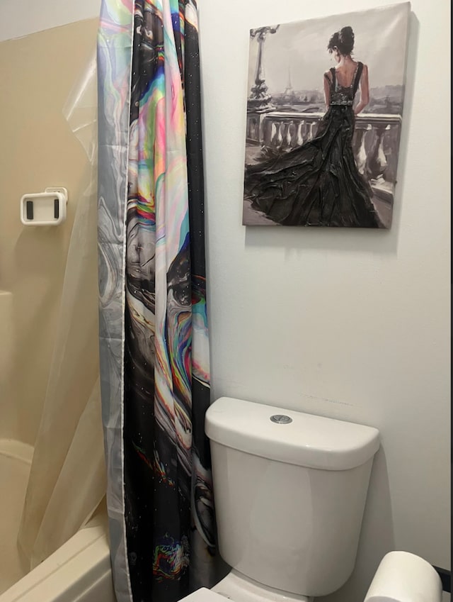 bathroom featuring shower / tub combo and toilet