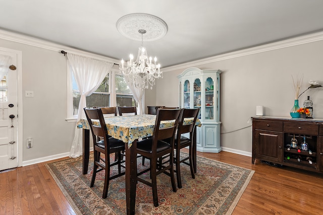 dining space with an inviting chandelier, crown molding, and dark wood-type flooring