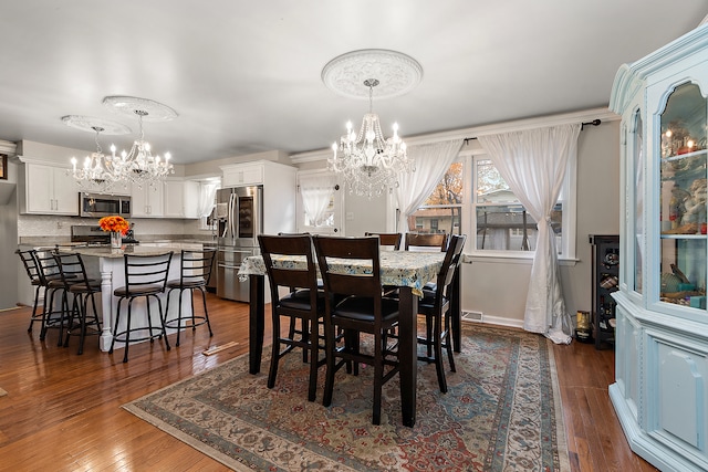 dining area featuring a notable chandelier and dark hardwood / wood-style floors