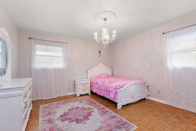 bedroom with light parquet flooring and an inviting chandelier