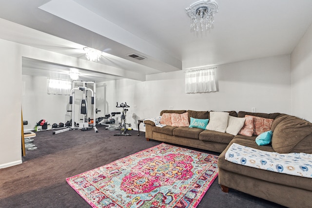 living room featuring dark colored carpet, plenty of natural light, and a notable chandelier