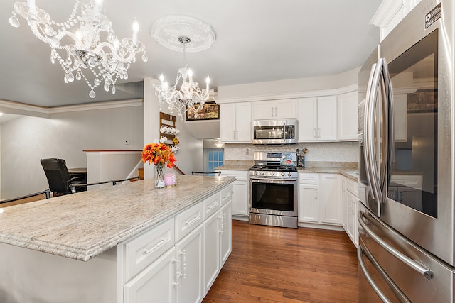 kitchen with dark hardwood / wood-style flooring, stainless steel appliances, white cabinetry, a notable chandelier, and a kitchen island