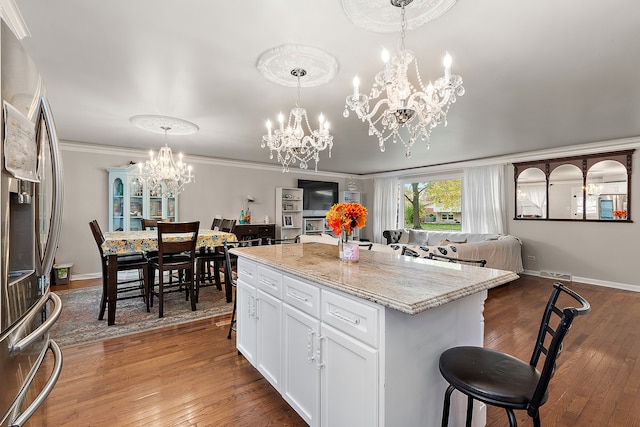 kitchen featuring a kitchen island, wood-type flooring, stainless steel refrigerator with ice dispenser, and white cabinetry