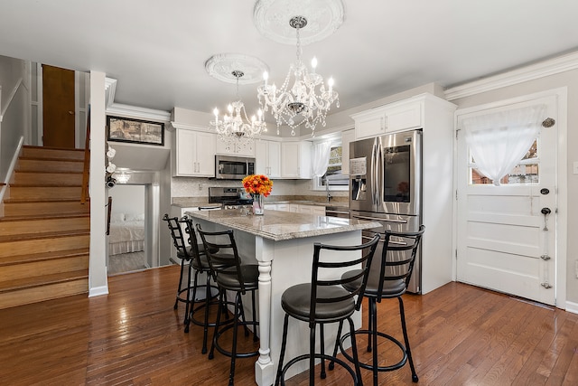 kitchen with white cabinetry, stainless steel appliances, and dark hardwood / wood-style floors