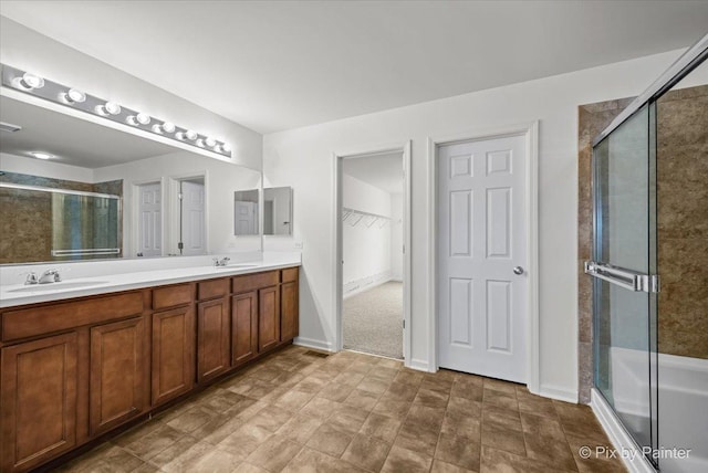 bathroom featuring a shower with door and vanity