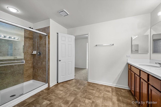 bathroom with a shower with door and vanity