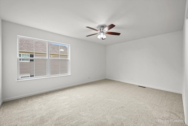 empty room featuring ceiling fan and carpet