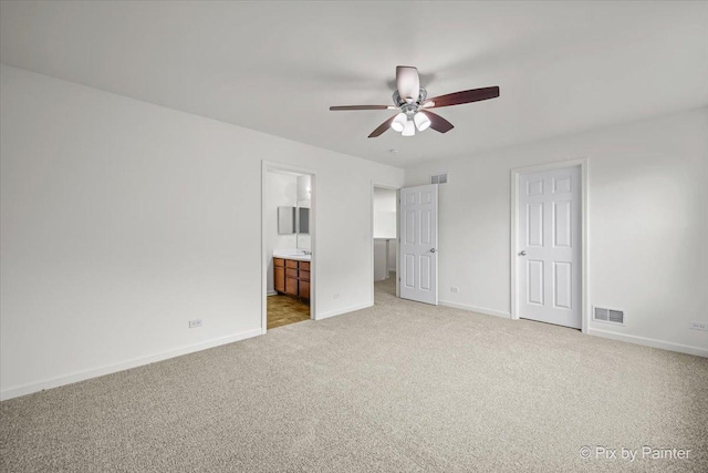 unfurnished bedroom featuring connected bathroom, ceiling fan, and light carpet