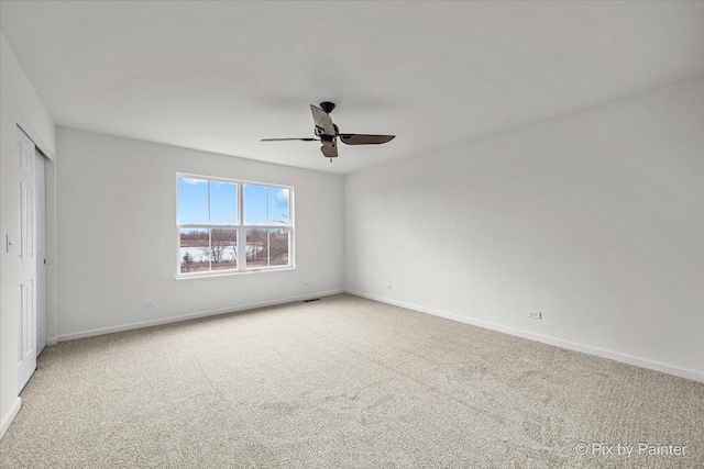 carpeted spare room with ceiling fan