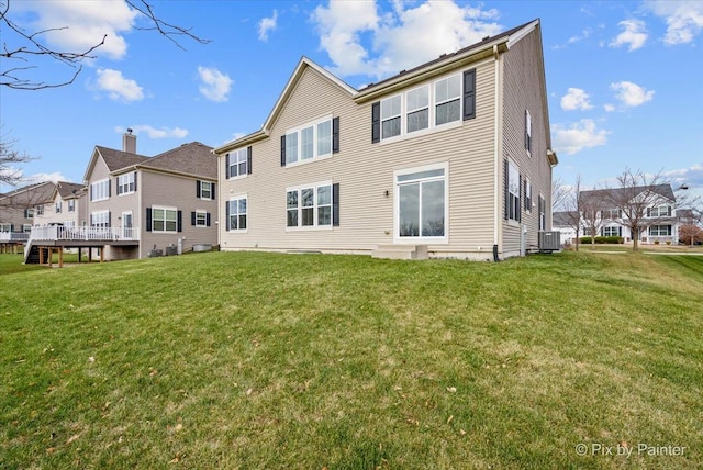 back of property featuring a lawn and central AC