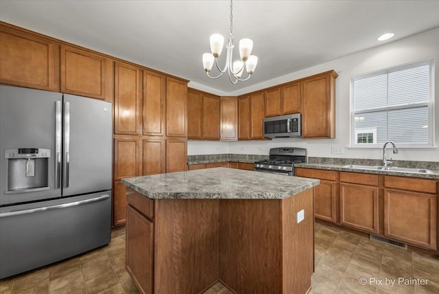 kitchen with a center island, sink, decorative light fixtures, appliances with stainless steel finishes, and a notable chandelier