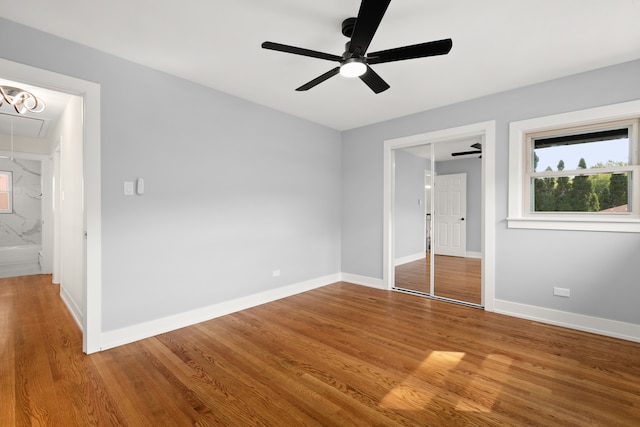 unfurnished bedroom with hardwood / wood-style floors, connected bathroom, a closet, and ceiling fan