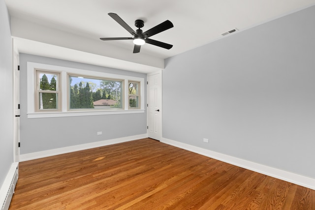 unfurnished room with ceiling fan, a baseboard radiator, and light wood-type flooring