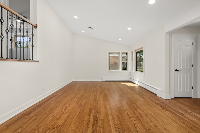 unfurnished room with light hardwood / wood-style floors, a baseboard radiator, and lofted ceiling