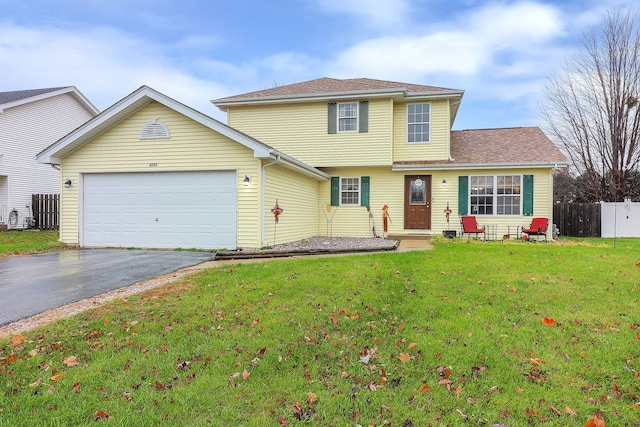 view of property featuring a front yard and a garage